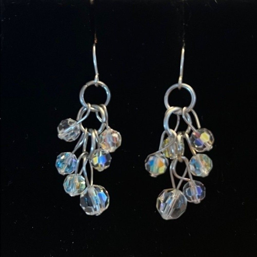 Handcrafted silver tone earrings with clear stones that pick up a tons of light…